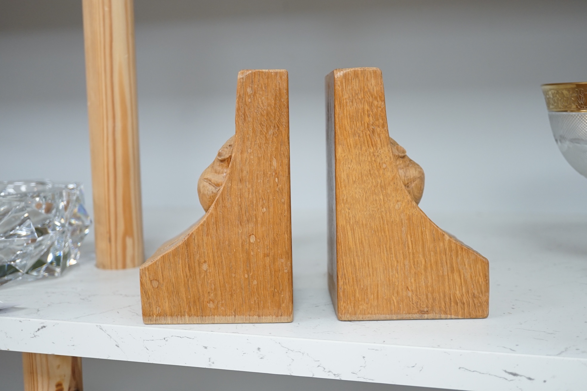 Workshop of Robert ‘’Mouseman’’ Thompson of Kilburn - a pair of English oak single mouse bookends, each with carved mouse trademark, 15cm high. Condition - good.